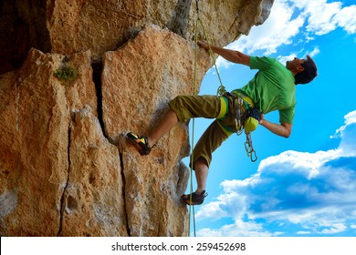 Rock Climber Climbs On A Rocky Wall