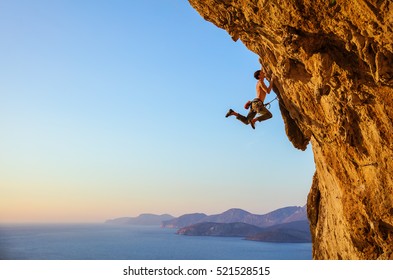 Rock Climber Jumping On Handholds While Climbing Overhanging Cliff