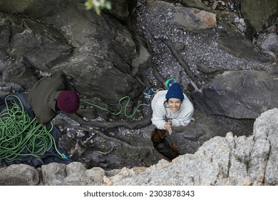 rock climber. man climbing back. traditional crag climber. cliff in the woods. climber on a natural cliff in a rough environment. smiling woman climbing. happy climber smiling. climbing photography