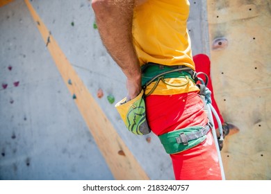 Rock Climber Man Shoved His Hands Into A Bag Of Magnesia Powder Behind His Back. Close-up.