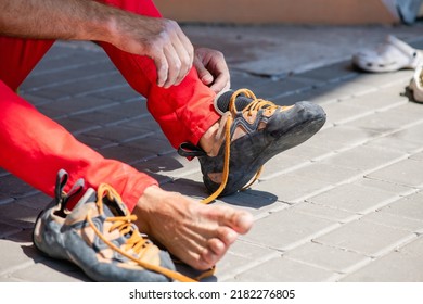 Rock climber puts on climbing shoes and ties shoelaces. Preparing to climbing. Male hands close-up - Powered by Shutterstock