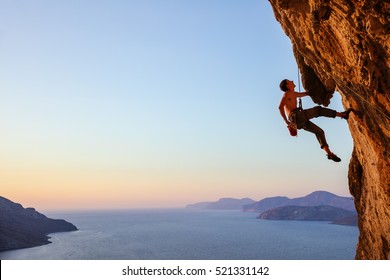 Rock climber resting while climbing overhanging cliff