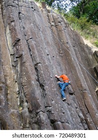 A rock climber scales The Columns, a vertical basalt cliff in Skinner Butte Park in Eugene Oregon USA.