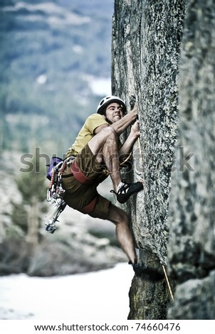 Rock climber clinging to a cliff.