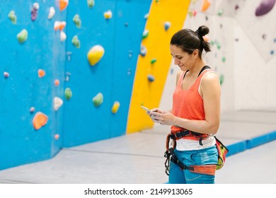 Rock climber woman looking at smartphone. - Powered by Shutterstock