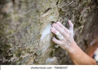 Rock Climber's Hand Gripping Small Hold On Natural Cliff, Shallow Depth Of Field