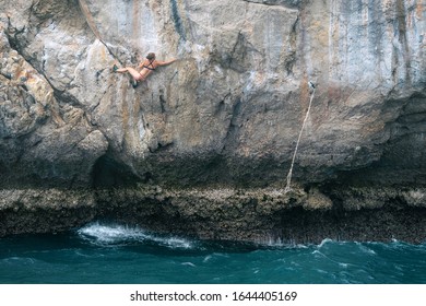 Rock Climbing (deep Water Solo) In Thailand. Sporty Girl In Bikini Climbs The Rock Above The Sea. 