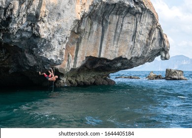 Rock Climbing (deep Water Solo) In Thailand. Climber (man) Climbs The Rock Above The Sea. Krabi Province.