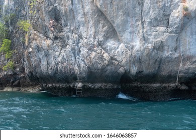 Rock Climbing (deep Water Solo) In Thailand. Guy Jumps From The Rock Into The Sea. 