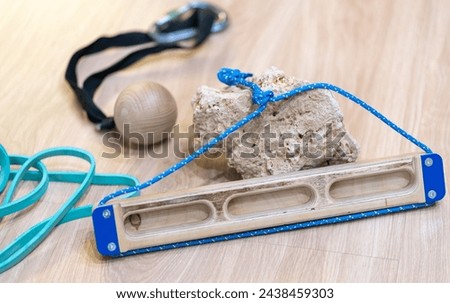 rock climbing gear hangboard fingerboard finger strength training equipment isolated on wooden floor