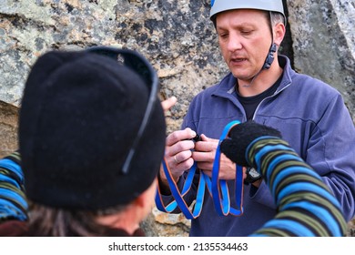 Rock climbing instructor is teaching how to perform the belay station. - Powered by Shutterstock