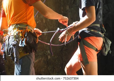 Rock climbing instructor is teaching how to tie the figure eight knot - Powered by Shutterstock