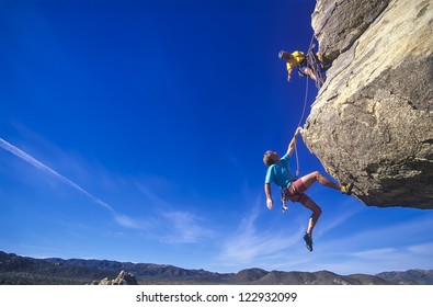 Rock climbing team struggle for success on a challenging ascent. - Shutterstock ID 122932099