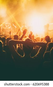 Rock Concert, Cheering Crowd In Front Of Bright Colorful Stage Lights, Hands Behind The Head With Pleasure From The Show