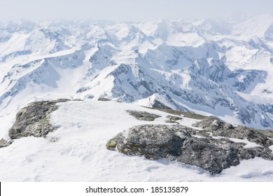 Rock covered with snow with mountain in the back, view from Ankogel, Austria