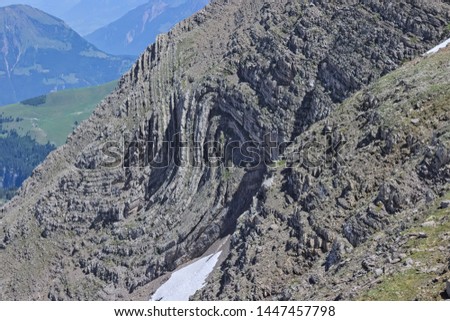 Rock folded into syncline in alpine swiss mountains. S-Fold found at steep mountain side.