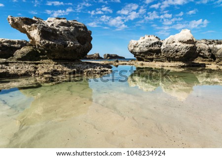 Rock formation and ocean pool with reflections in the sea at Peterborough beach along the Great Ocean Road, Victoria, Australia