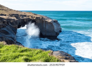 Rock formation on a beach dramatic beautiful Tunnel Beach Dunedin famous blue calm waves 
