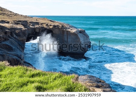 Rock formation on a beach dramatic beautiful Tunnel Beach Dunedin famous blue calm waves 