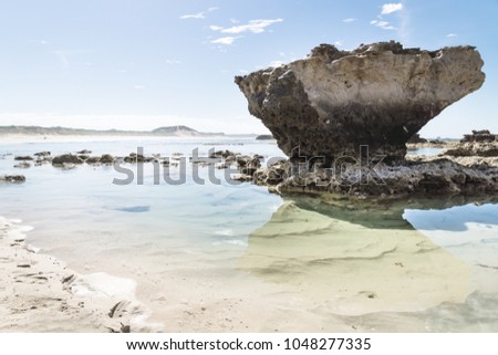 Rock formation with reflection and light clear oceanwater at Peterborough beach along the Great Ocean Road, Victoria, Australia