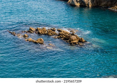 Rock Formations In Ocean Cove Near Craggy Coastline.