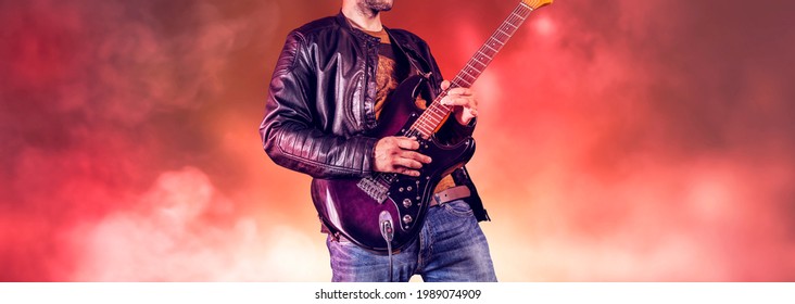 Rock Guitarist Plays Solo On An Electric Guitar. Artist And Musician Performs Like Rockstar. Guitar Player Performs On Stage. 