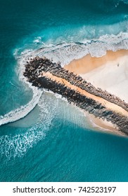 Rock jetty in Australia, crashing waves and amazing blue