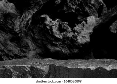 A Rock Mineral Product Display Shelf, Showing A Rough Texture To The Platform With A Blurred Tree Root Background.