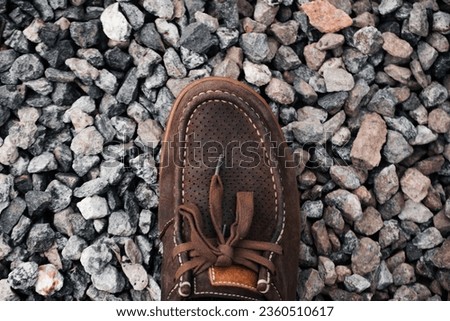 rock pebbles and shoe on industrial gounds