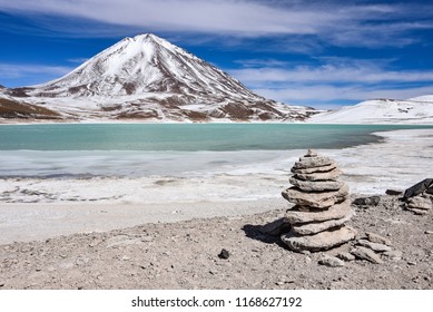 A rock pile stands in front of Laguna Verde and the Licancabur Volcano, Reserva Eduardo Avaroa, Sud Lipez province, Bolivia - Powered by Shutterstock