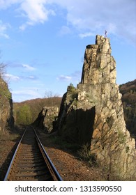 Rock pillar named "Pikovická jehla" ("Pikovice Needle") in the valley of Sázava river, Czech republic. A train track of a local railway passes nearby.  - Shutterstock ID 1313590550