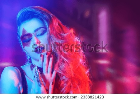Rock and Pop music. Close-up of a rock star girl with bright glitter makeup and hair in glam rock style in colored stage lighting. Rock accessories. Place for text.