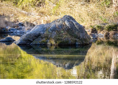 Rock at the river with reflection.