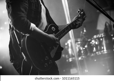 Rock And Roll Music Black And White Background, Electric Guitar Player On A Stage, Photo With Soft Selective Focus