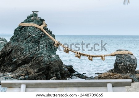 A rock with a rope tied to it is on a beach