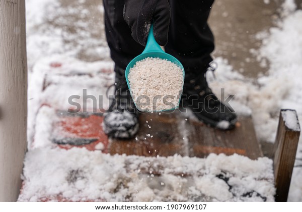 rock salt ice melt is being spread on\
your walkway to melt the ice and snow from your\
path