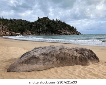 a rock sandy beach next to a body of water at Balding Bay on Magnetic Island