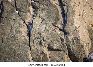 Rock Texture. Snow And Cracks On The Surface Of The Cliff. Natural Stone Background.