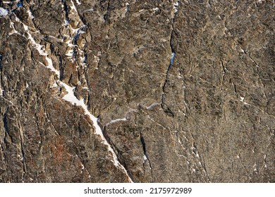 Rock Texture. Snow And Cracks On The Surface Of The Cliff. Natural Stone Background.