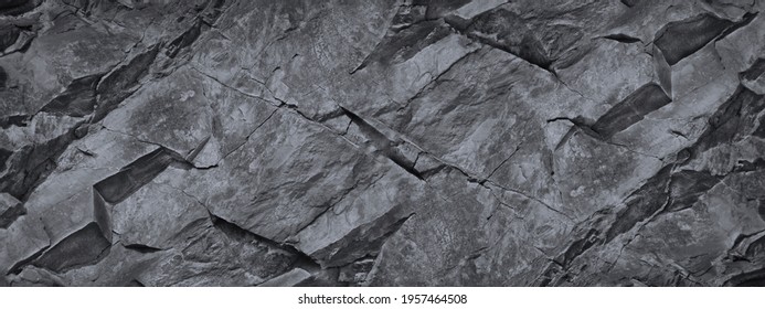Rock texture. The surface of the mountain is like a stone wall. White gray grunge background with copy space for design. Wide banner. Panoramic. Volumetric 3D effect.
