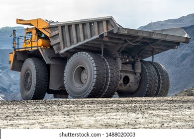 Rock Transportation By Dump Trucks. Large Quarry Yellow Truck. Transport Industry. Mining Truck Is Driving Along A Mountain Road.