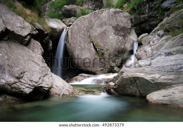 Rock and Waterfall: huge lump of rock\
separates a creek into two\
waterfalls