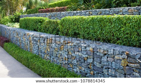 Rock and wire gabions used as retaining walls in a multi tiered garden design 