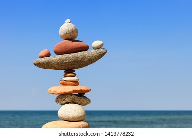 Rock zen pyramid of colorful pebbles on a beach on the background of the sea. Concept of Life balance, harmony and meditation