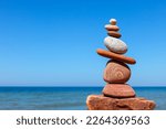 Rock zen pyramid of stones of different shapes on the beach. Concept of Life balance, harmony and meditation