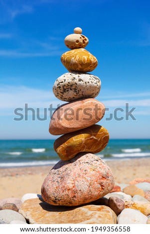 Rock zen pyramid of white and pink pebbles on the beach. Concept of Life balance, harmony and meditation