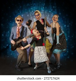 Rockabilly Family Band Having Fun Playing Music And Posing With Vintage Microphone - 1950s Style
