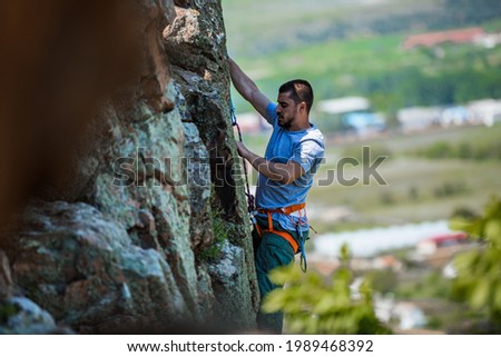 Rockclimber with dreadlocks climbing a mountain