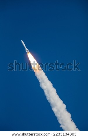 A rocket blasting off and soaring into space in the sky going upward after lifting off from launch pad. Digitally enhanced. Elements of this image furnished by NASA.