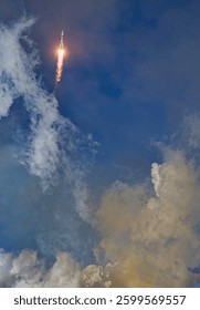Rocket launch against clouds in the sky. Abstract background. Blue sky. Elements of this image furnished by NASA